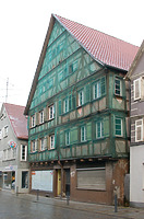 Ansicht von Nordwesten mit Blick auf die straßenseitige Giebelfront. Das im Kern aus dem 17. Jahrhundert stammende Gebäude ist schon seit Jahren hinter einer Schutzabhängung verborgen. / Wohn- und Geschäftshaus in 88512 Mengen (28.11.2015 - Stefan Uhl)