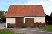 Gesamtansicht von Süden. Der mittelalterliche Kernbau umfaßt die drei westlichen (linken) Zonen, die östliche (rechte) Zone wurde erst später angefügt. Die Fachwerkkonstruktion des Unterbaues ist durch jüngeren Verputz fast vollständig verdeckt.  / Firstständerscheune in 72622 Nürtingen-Zizishausen (09/2017 - Stefan Uhl)