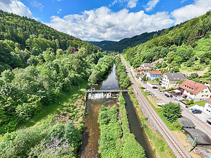 Wehr Neuenbürg an der Enz. Schräg-Luftbild, Blick in Richtung Südwest (enzaufwärts). Sicht von Unterwasser mit Lage des Flusses Enz im Tal / Wehr Neuenbürg an der Enz, Badwehr T215 in 75305 Neuenbürg,  keine genauere Zuordnung (06/2024 - baumass GbR - architekturvermessung & baudokumentation, Dipl.-Ing. Meike Hoffmann, Dipl.-Ing. Marc Wietheger
)