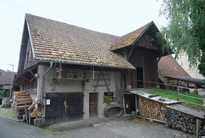 Nordseite mit Rampe und Hocheinfahrtstor, im Erdgeschoss von links Schopftor, Stalltür und Tür zum Futtergang unter der Brücke / Bauernhaus in 79804 Dogern (2023 - Stefan King, Freiburg)