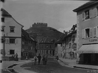 Blick von Süden in den nördlichen Bereich der Hauptstraße; im Hintergrund der Schlossberg; links im Vordergrund das Gasthaus Krone (1895) / Gasthaus und Hotel in 79219 Staufen, Staufen im Breisgau (24.04.1895 - Stadtarchiv Staufen (von Rudolf Hugard))