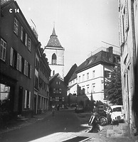 Straßenansicht in Staufen; im Hintergrund der Turm der katholischen Pfarrkirche St. Martin (1965) / Kath. Pfarrkirche St. Martin, Kirchturm in 79219 Staufen, Staufen im Breisgau (Bildindex Foto Marburg, Foto: E. Groth-Schmachtenberger; Aufnahme-Nr. B 14.937/3; Aufn.-Datum: 1965)